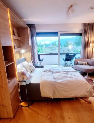 a bedroom with a large bed and a large window at ALPartement Seefeld in Seefeld in Tirol
