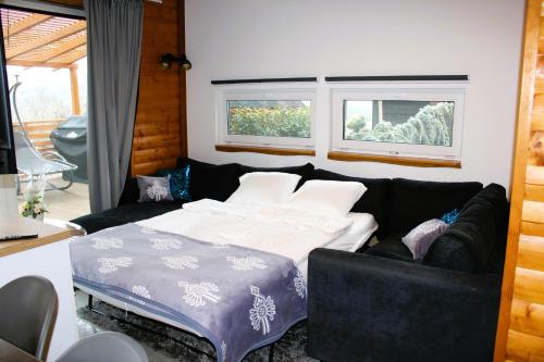 a living room with a bed and a couch at H25 Vendégház in Sóskút