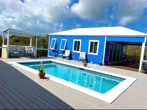 a blue tiny house with a swimming pool at Atlantic Blue Cottages # 1 