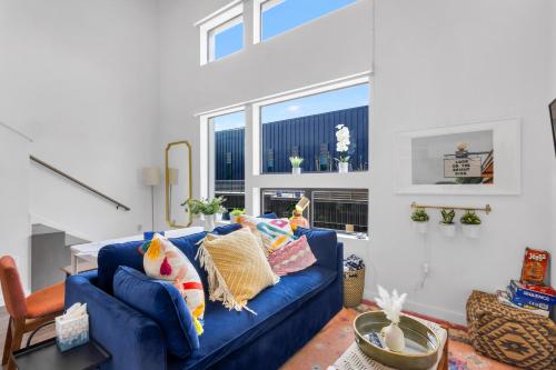 a living room with a blue couch with pillows at Austin Stylish Studio in Austin
