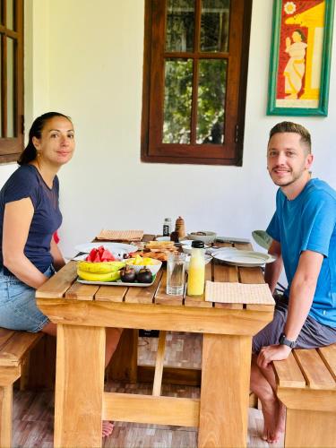 a man and woman sitting at a table with a meal at Aroma Villa Homestay in Polonnaruwa
