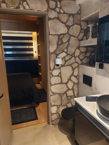 a kitchen with a stone wall and a doorway at The Kefalos Loft in Platánion