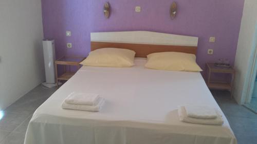 - une chambre avec un lit blanc et 2 serviettes dans l'établissement Apartments Antica, à Šimuni