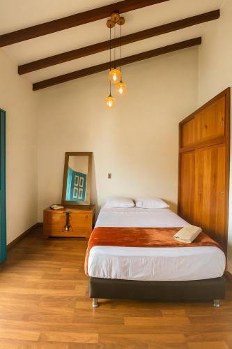 a bedroom with a large bed with a wooden headboard at Soluna Apartamento Jericó Parque in Jericó