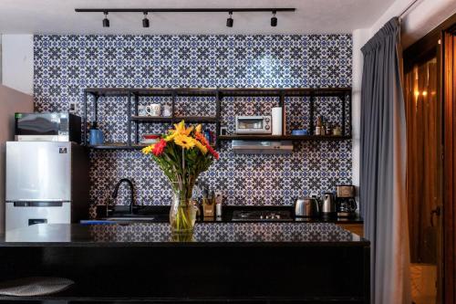a kitchen with a vase of flowers on a counter at Makawe in Sayulita