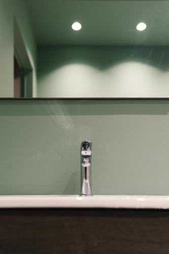 ein Waschbecken mit Spiegel und Wasserhahn in der Unterkunft Living Calabriando in Reggio di Calabria