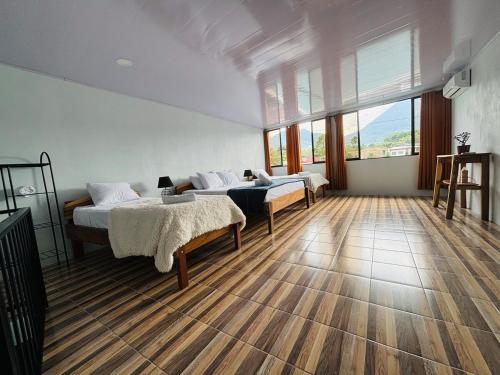 a bedroom with two beds and a large window at SUA Luxury Arenal Volcano View Apartments in Fortuna