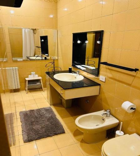 a bathroom with a sink and a toilet and a mirror at Colosseum's Custodian - Apartment 115 m2 in Rome