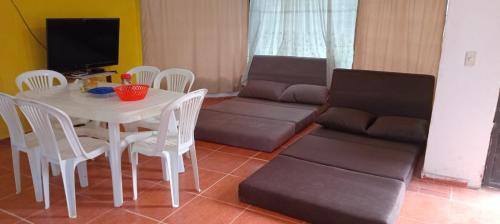 a living room with a table and a couch at Quinta AM Vacaciones y Turismo in Santa Isabel