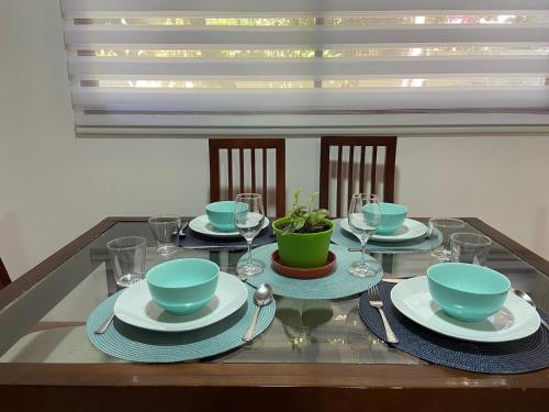 a table with plates and bowls and wine glasses at Comfortable modular home in San Esteban