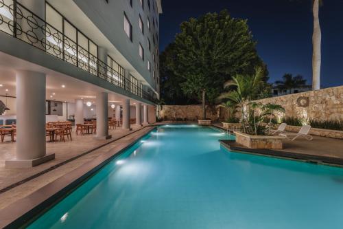 a swimming pool in front of a building at night at Gran Hotel Panamericana, Mérida in Mérida