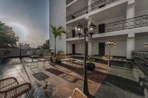 a patio with chairs and tables on a building at Gran Hotel Panamericana, Mérida in Mérida