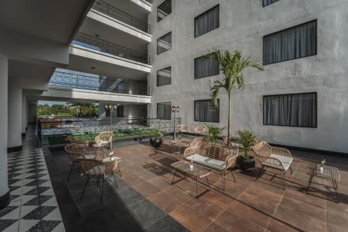 a courtyard with chairs and tables in a building at Gran Hotel Panamericana, Mérida in Mérida