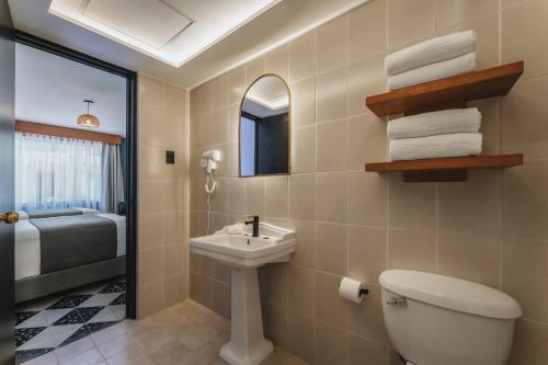 a bathroom with a toilet and a sink and a mirror at Gran Hotel Panamericana, Mérida in Mérida