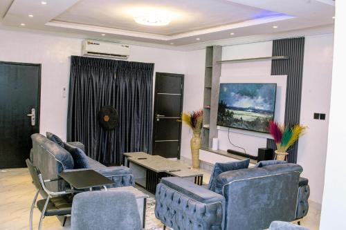 a living room with blue chairs and a table at Afstar Apartments in Lagos