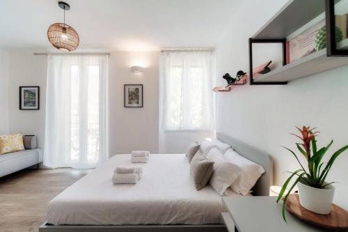 a white bedroom with a bed and a couch at Casa Batèl Suites & Apartments - By Breva Collections in Como