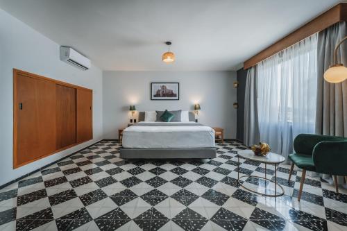 a hotel room with a bed and a couch at Gran Hotel Panamericana, Mérida in Mérida