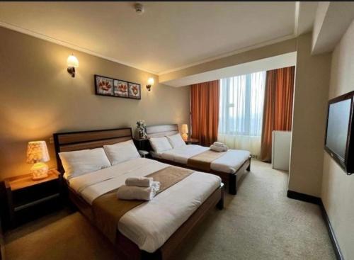 a hotel room with two beds and a television at N Royal Residence By Nairi in Yerevan