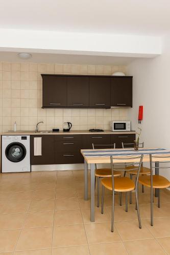 una cucina con tavolo, sedie e lavandino di Casa di Mar a Santa Maria