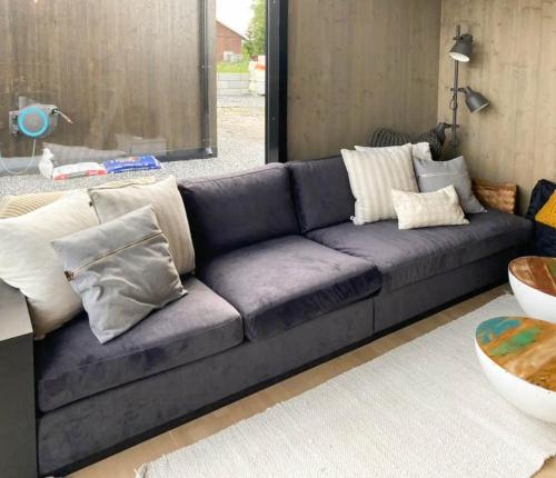 a blue couch with pillows in a living room at Relax In This Cozy Family Cabin 