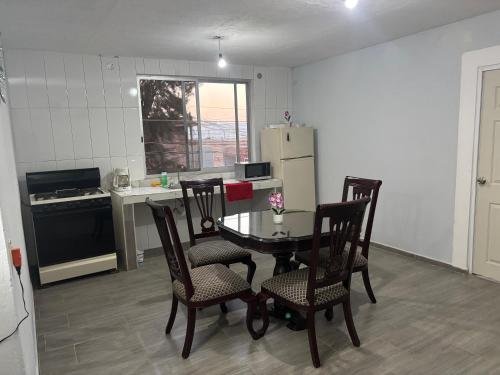 a kitchen with a table and chairs and a refrigerator at Depa Perdiz in Tepatitlán de Morelos