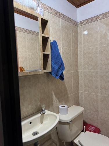 a bathroom with a white toilet and a sink at Comfortable Apartment with a Starry Night Theme in Guatapé