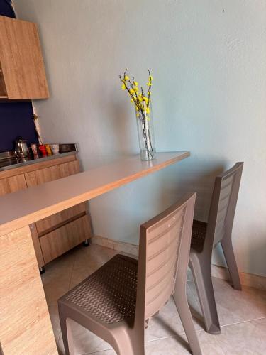 a table with two chairs and a vase with yellow flowers at Comfortable Apartment with a Starry Night Theme in Guatapé