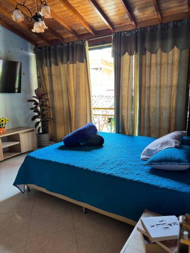 a bedroom with a blue bed with pillows on it at Comfortable Apartment with a Starry Night Theme in Guatapé
