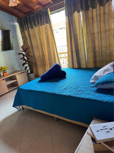 a bed with blue sheets and pillows in a room at Comfortable Apartment with a Starry Night Theme in Guatapé