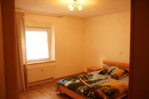 ヘルツォーゲンアウラッハにあるFortl's Apartmentのベッドと窓のある寝室