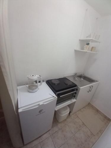 a small kitchen with a sink and a stove at Soba Dujaković in Banja Vrućica