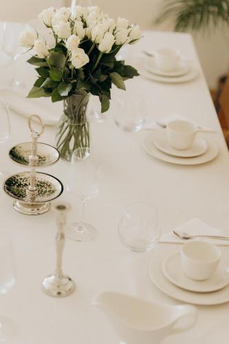 a white table with a vase of white flowers on it at FamilyVilla, new 4 Luxury Big Apartments, parking in Prague