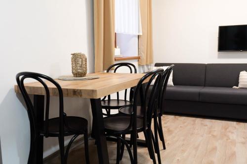 a dining room table with chairs and a couch at Horský klid Klínovec in Loučná pod Klínovcem