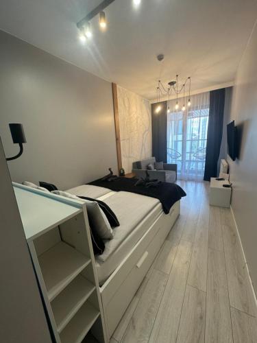 グダニスクにあるWyspa Spichrzów Residenceの大きなベッドと机のある寝室