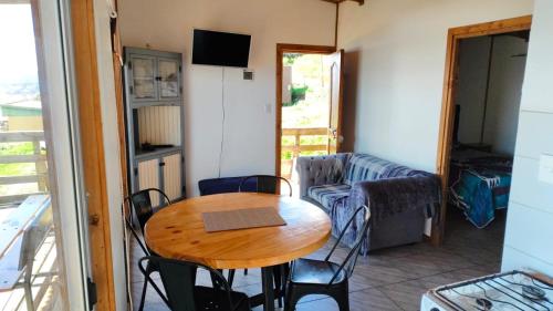 a room with a table and chairs and a couch at Cabañas Refugio Costero in Las Lomas