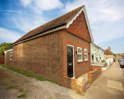 a brick building with a door on a street at The Old Coach House -Pevensey in Pevensey