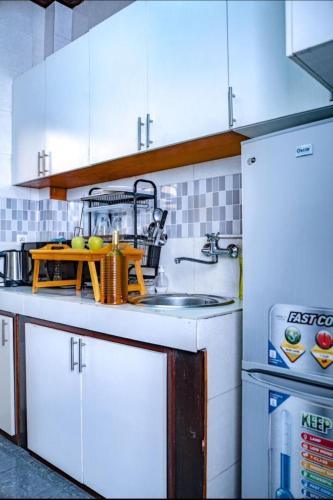 a kitchen with white cabinets and a sink at New Apparts 3 Douala in Douala