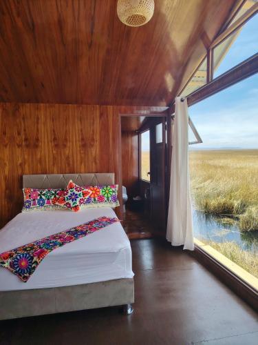 a bedroom with a bed and a large window at Sky Domo Titicaca Lodge in Puno