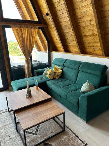 a living room with a green couch and a table at Atrijland Cazin in Cazin