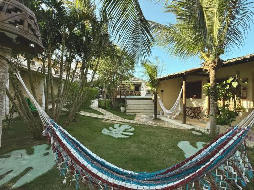 a yard with a hammock in front of a house at Pousada da Renata in Jericoacoara