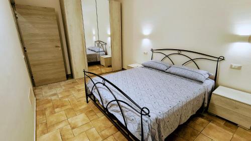 a bedroom with a bed in a room with a mirror at L'Antico Borgo di Leonardo in Monte San Biagio