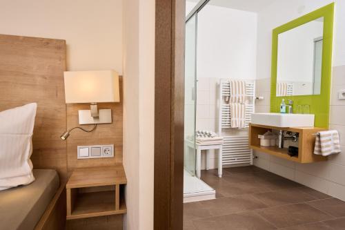 a bathroom with a bed and a sink and a mirror at Gasthaus Zum Hirschen in Staufen im Breisgau