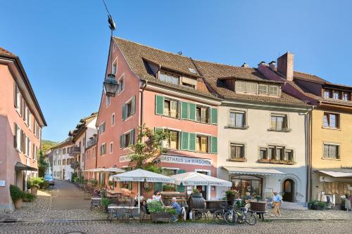 a street with tables and umbrellas in front of buildings at Gasthaus Zum Hirschen in Staufen im Breisgau
