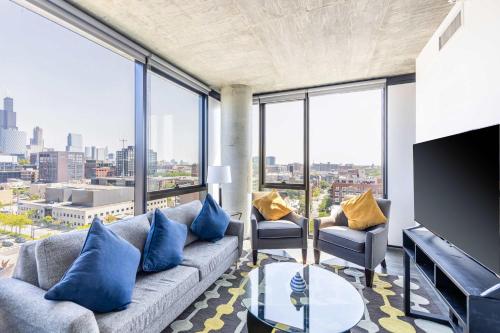 a living room with a couch and chairs and windows at Bright & Modern 2BR Perfect City Escape in Chicago