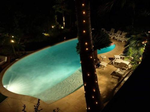 a swimming pool at night with chairs and a swimming pool at Villa spa hamman sauna Piscine 9 chambres in Juan-les-Pins