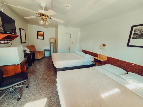 a bedroom with two beds and a ceiling fan at Norfolk Motel in Fredericton
