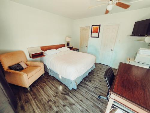 a hotel room with a bed and a chair at Norfolk Motel in Fredericton