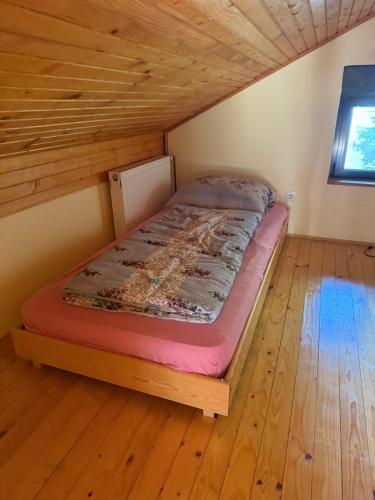 a bed in a room with a wooden floor at Pasha Vlašić in Šišava