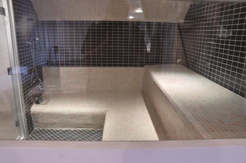 a bathroom with a shower with a tub and tiles at Villa spa hamman sauna Piscine 9 chambres in Juan-les-Pins