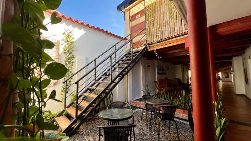 a balcony with tables and chairs and a staircase at Hotel Villa de Mompox in Mompos